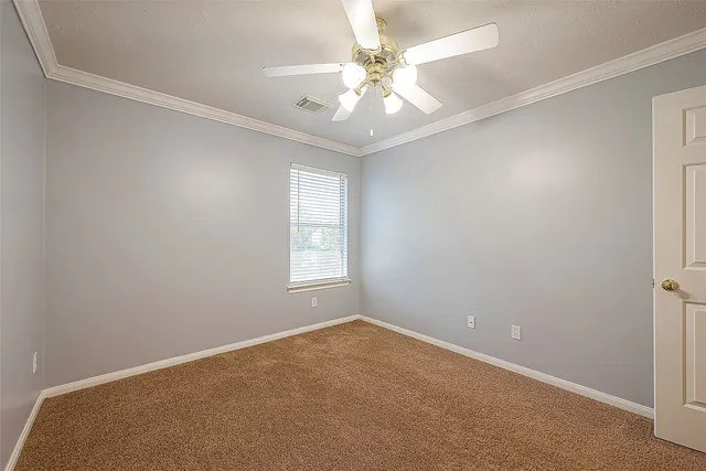 an empty room with windows and chandelier fan