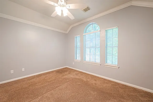 an empty room with windows and chandelier fan