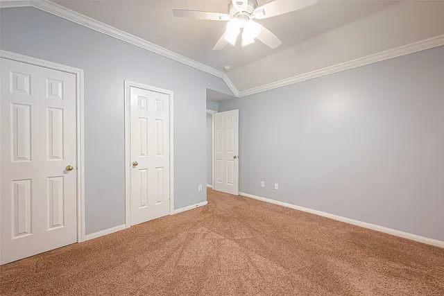 an empty room with a chandelier fan and closet area