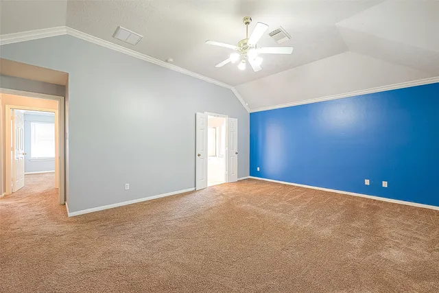 an empty room with windows and chandelier fan