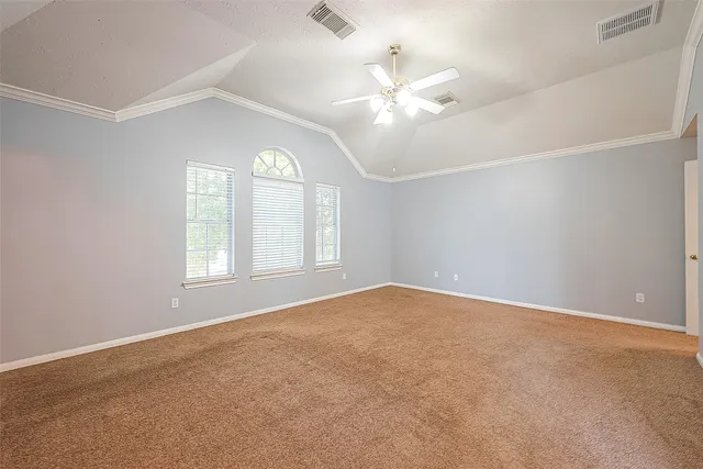 an empty room with windows and chandelier fan