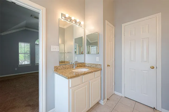 a bathroom with a granite countertop sink and a mirror