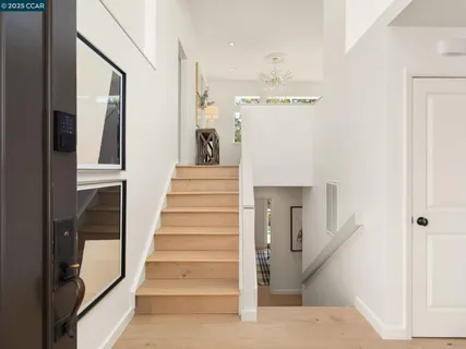 a view of staircase with lots of frames and white walls
