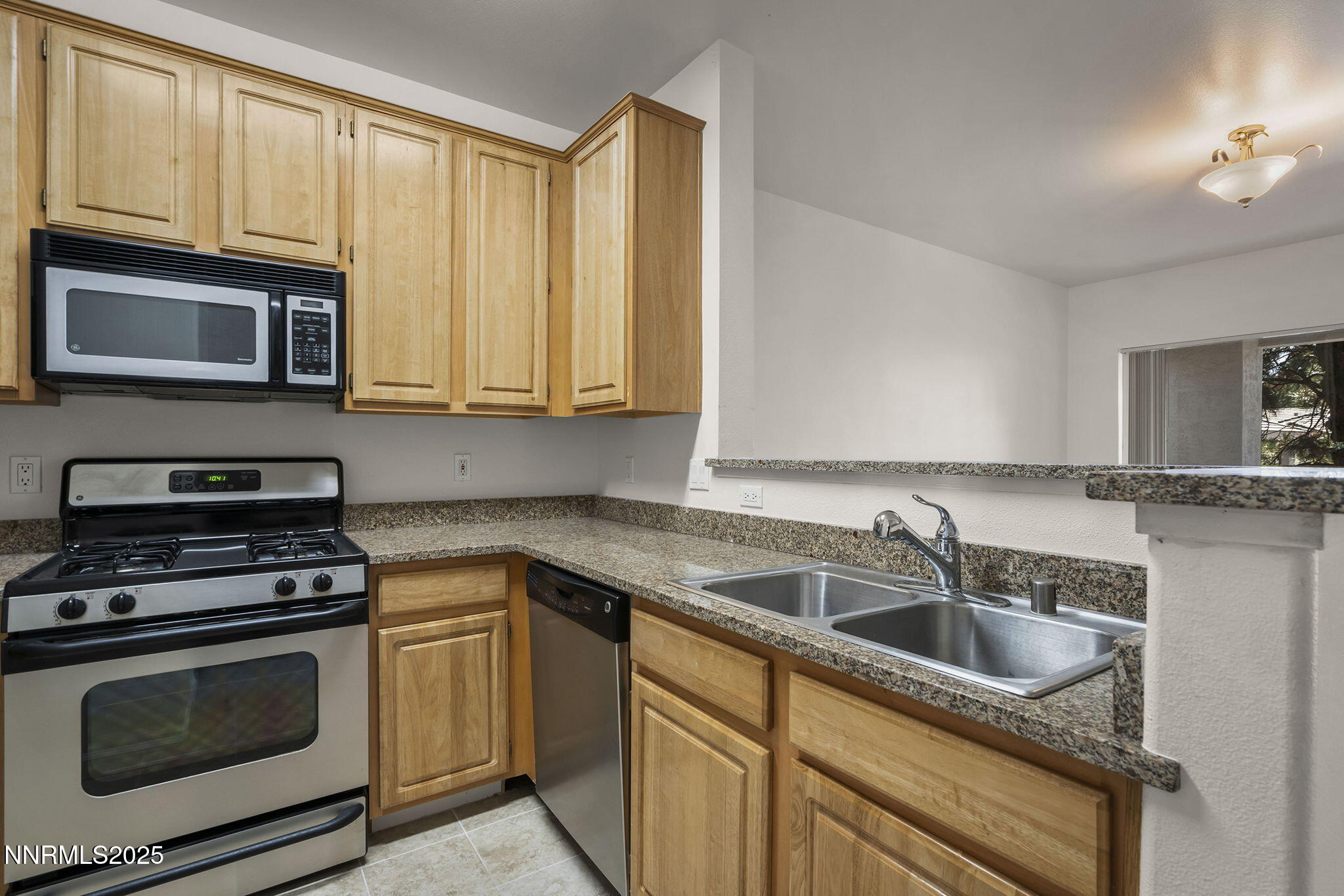 900 South Meadows Parkway, Unit 622 Reno, NV 89521 - Photo 11 of 30 a kitchen with granite countertop cabinets stainless steel appliances a sink and dishwasher