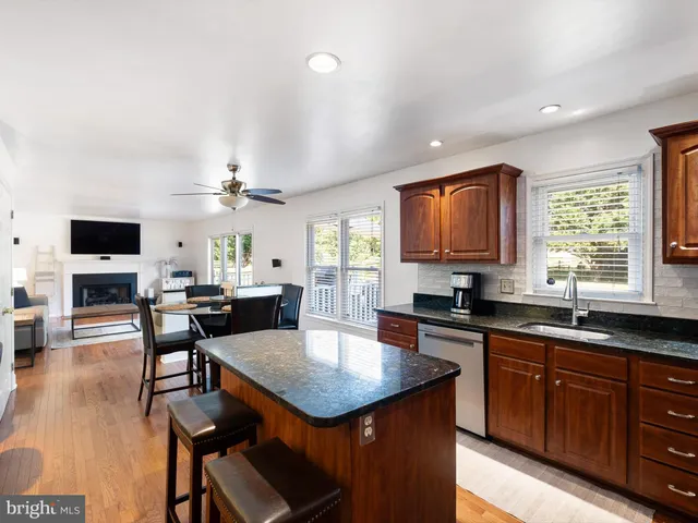 a kitchen with a stove a sink a microwave a dining table and chairs