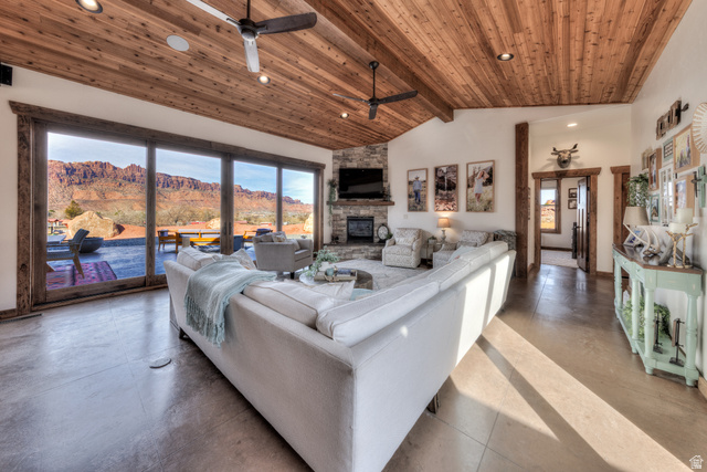 4173 Shadowfax Run, Unit 5 Moab, UT 84532 - Photo 12 of 41 Living room with a ceiling fan, concrete flooring, a high wood beamed ceiling, recessed lighting, and floor to ceiling stone fireplace