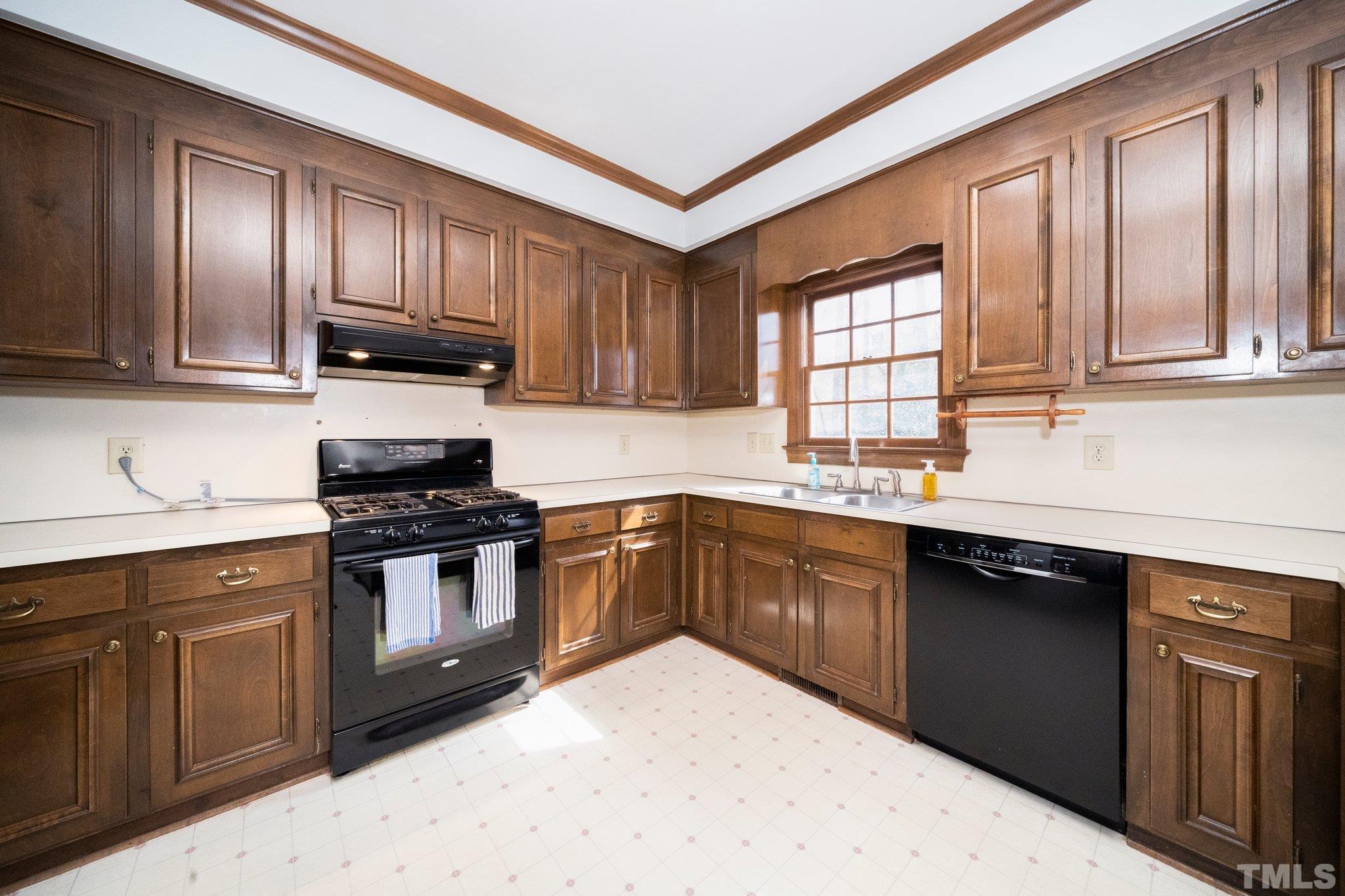 8612 Mourning Dove Road Raleigh, NC 27615 - Photo 12 of 29 a kitchen with granite countertop wooden cabinets stainless steel appliances and a sink