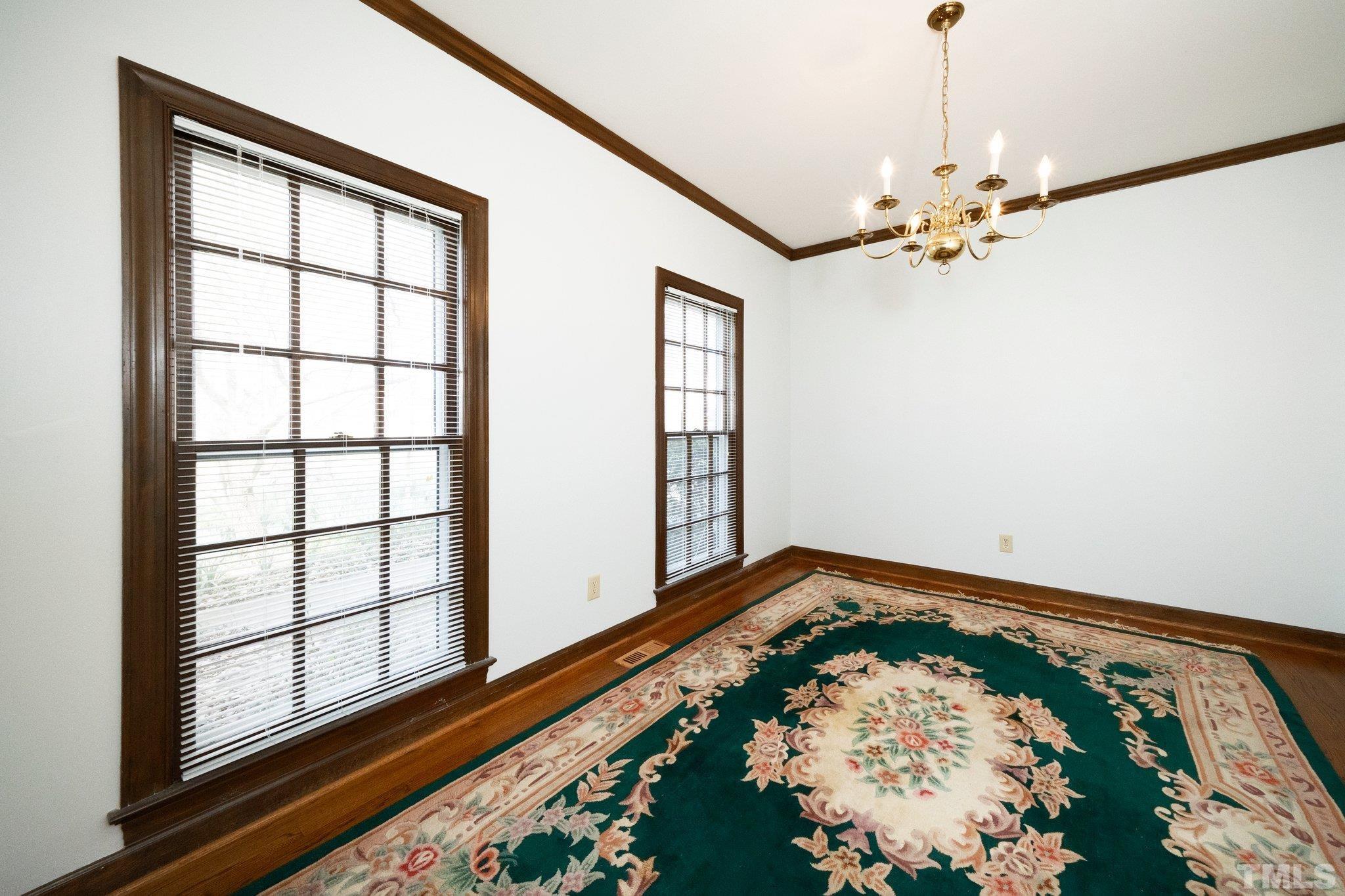 8612 Mourning Dove Road Raleigh, NC 27615 - Photo 5 of 29 an empty room with wooden floor fan and windows