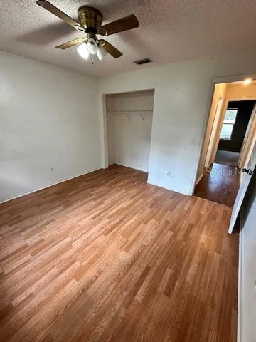 a view of an empty room with a chandelier fan