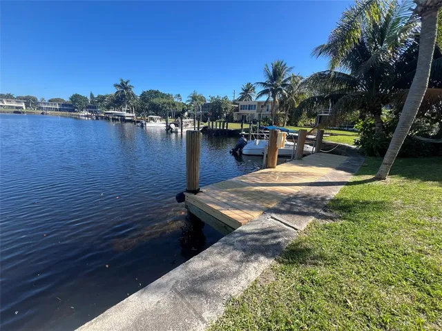 a view of a lake with boats and palm trees