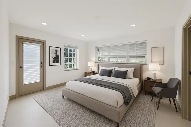 a bedroom with a large bed couch and a window