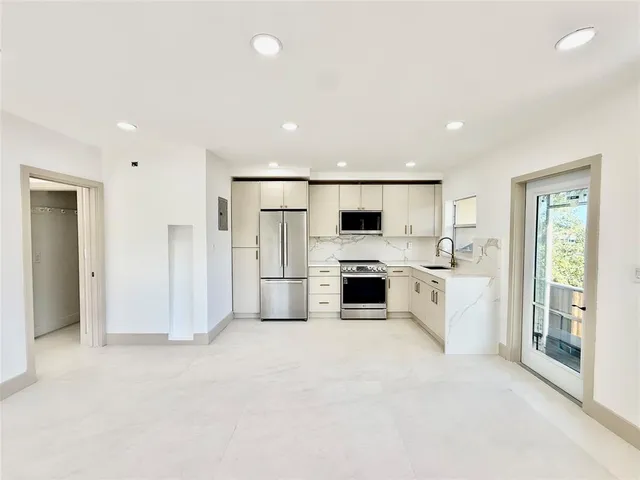 a kitchen with white cabinets and white appliances