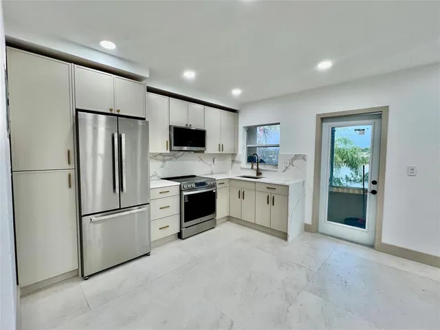 a kitchen with stainless steel appliances a refrigerator sink and stove