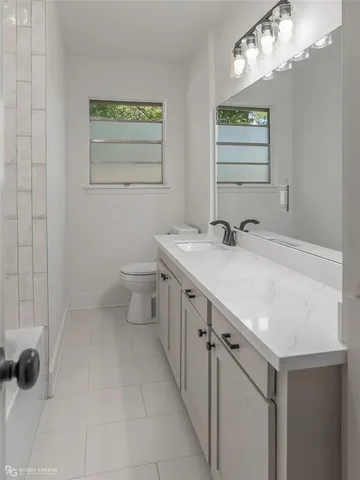 a bathroom with a sink a toilet and mirror