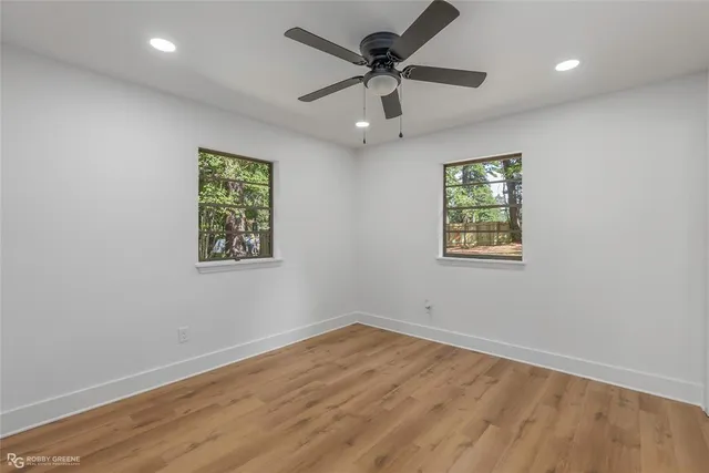 an empty room with a window and a ceiling fan