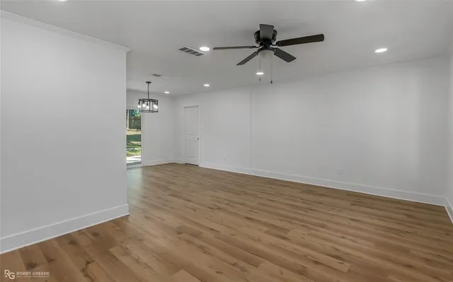 wooden floor in an empty room with a ceiling fan