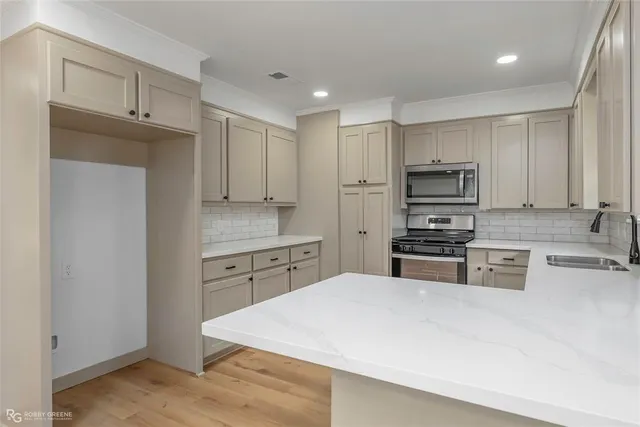 a kitchen with kitchen island white cabinets and refrigerator