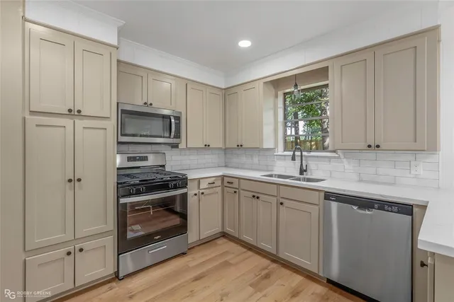 a kitchen with cabinets stainless steel appliances and sink