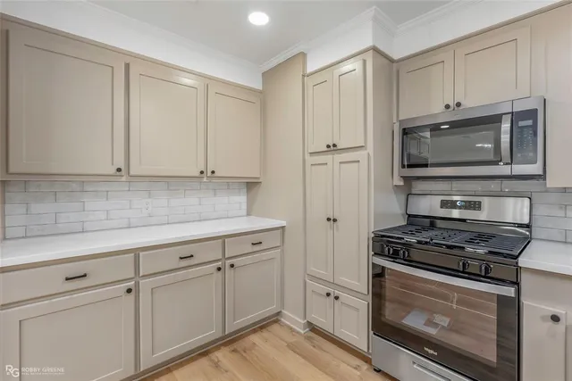 a kitchen with white cabinets and stainless steel appliances