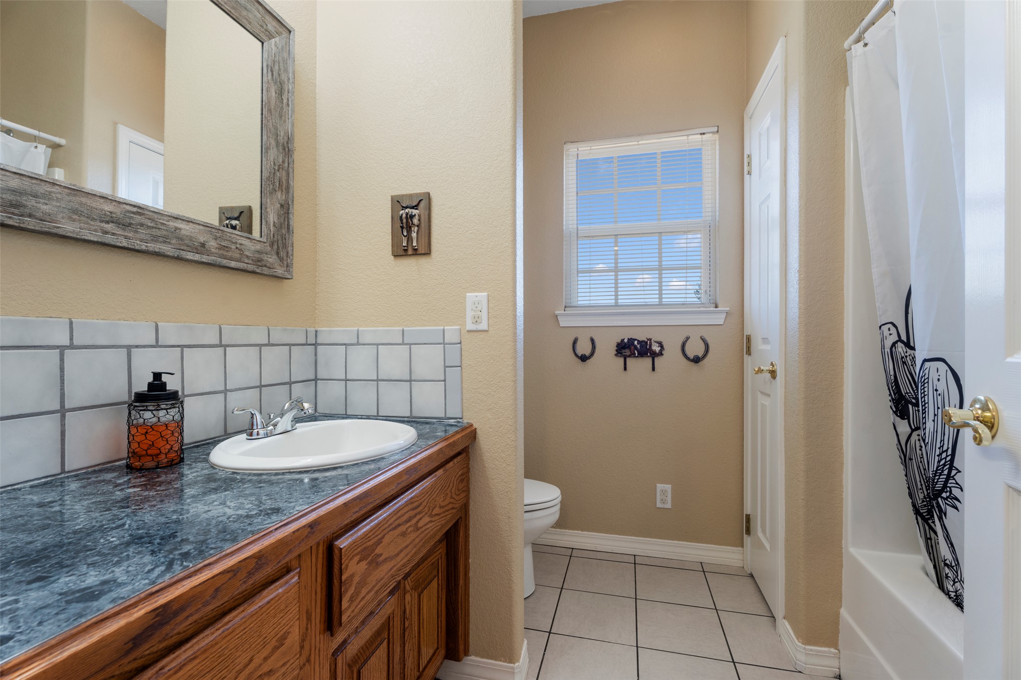 20233 East 570 Road Colcord, OK 74338 - Photo 25 of 39 Wood-finish vanity with an integrated sink and tiled backsplash