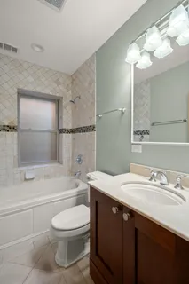 a view of an empty room with window and chandelier fan