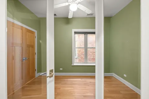 a view of an empty room with window and wooden floor