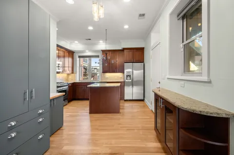 a kitchen with stainless steel appliances granite countertop a refrigerator a sink a stove and a microwave