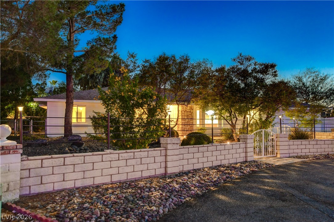7631 Bermuda Road Las Vegas, NV 89123 - Photo 54 of 64 An inviting gated entrance beckons to a charming home nestled amidst mature trees.