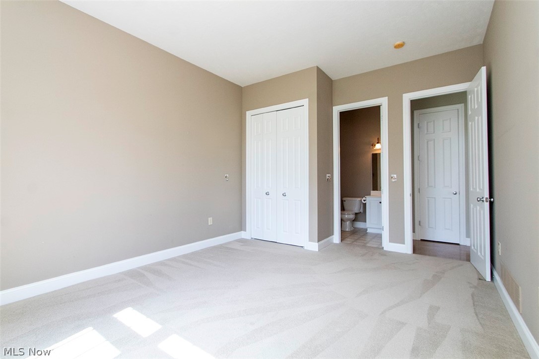 2201 Granger Road Medina, OH 44256 - Photo 23 of 34 Unfurnished bedroom featuring light carpet, ensuite bath, and a closet