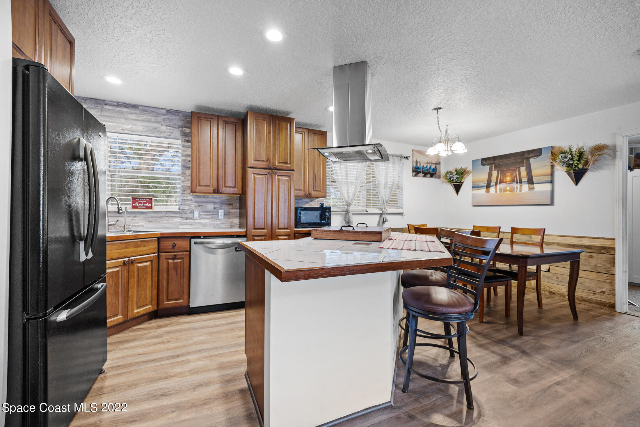 5480 Citrus Boulevard Cocoa, FL 32926 - Photo 13 of 43 a kitchen with kitchen island granite countertop wooden floors and white stainless steel appliances
