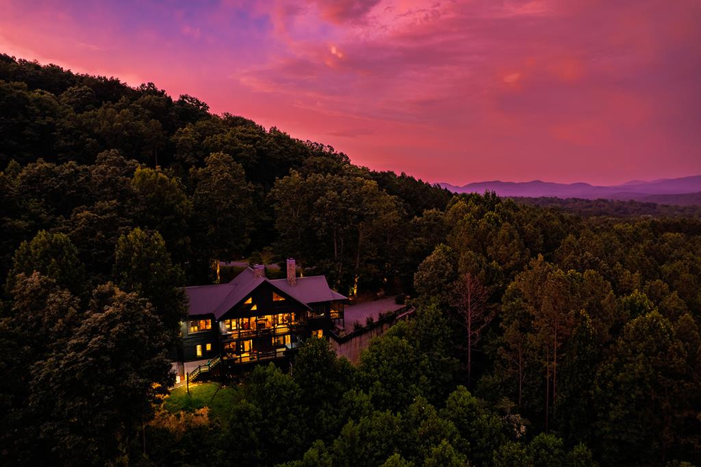 a backyard of a house with a table and chairs under an umbrella