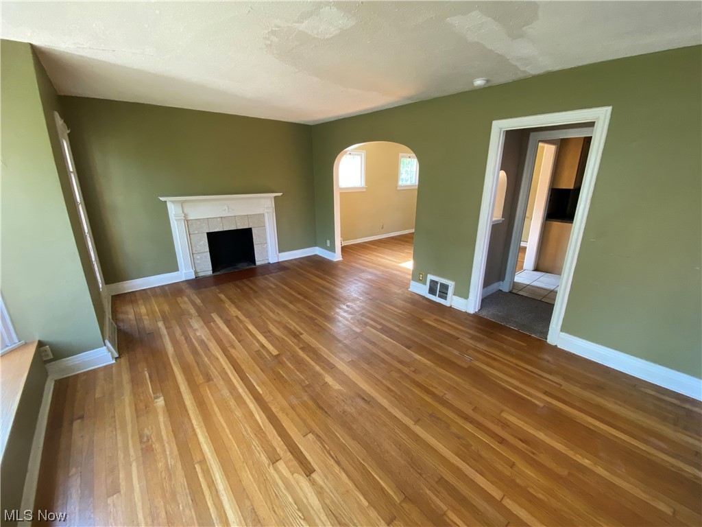 3630 Bainbridge Road Cleveland Heights, OH 44118 - Photo 5 of 21 Unfurnished living room featuring wood-type flooring and a tile fireplace