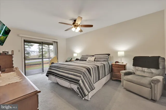 a spacious bedroom with a bed couch and window