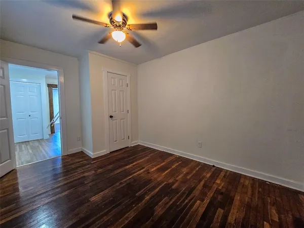 a view of an empty room with wooden floor
