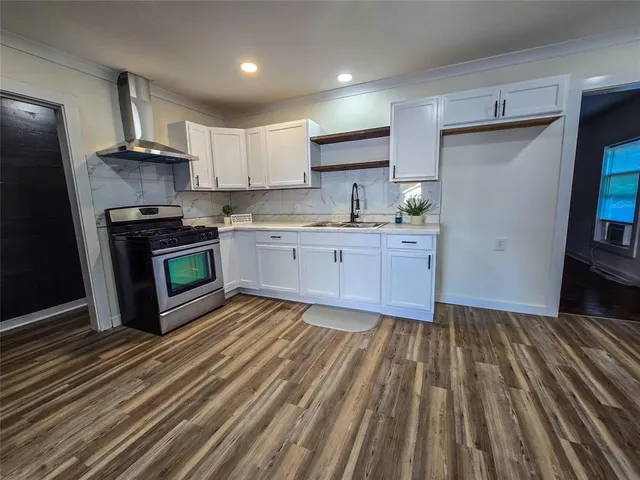a kitchen with granite countertop a sink stainless steel appliances and cabinets