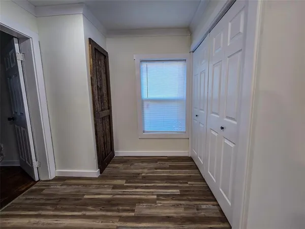 a view of a hallway with wooden floor and staircase