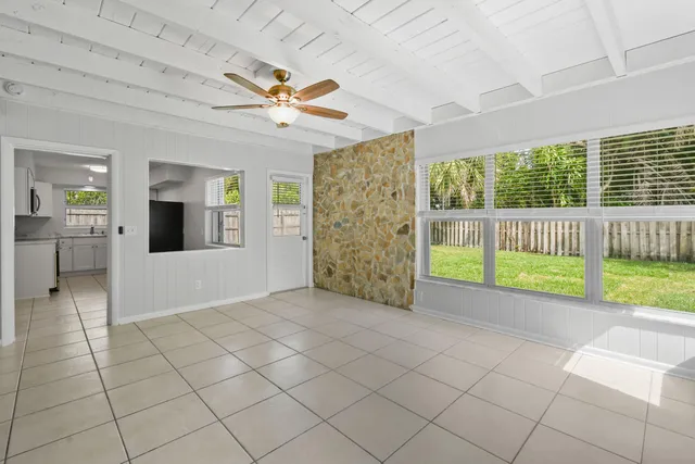 a view of a livingroom with a chandelier fan and windows