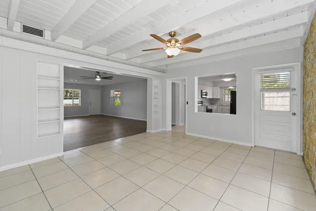 a view of a hallway with wooden floor and a bathroom