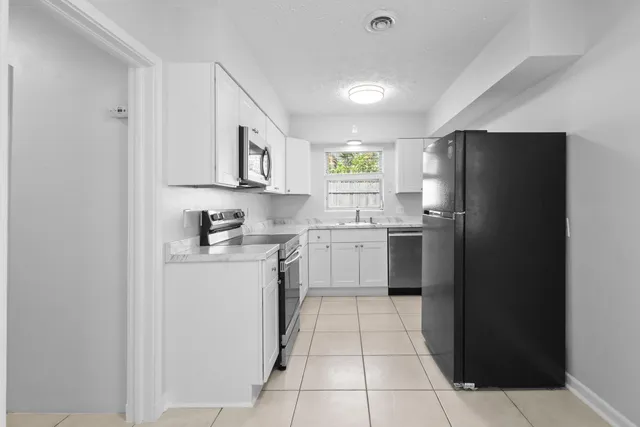 a kitchen with a refrigerator sink and cabinets