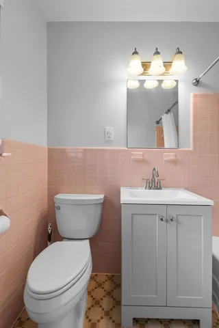 a bathroom with a toilet a sink and mirror