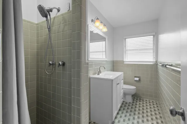 a bathroom with a sink toilet a shower and a window