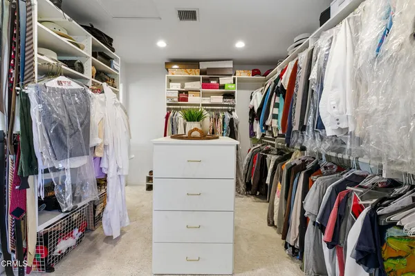 a bedroom with a bed a flat screen tv and dresser