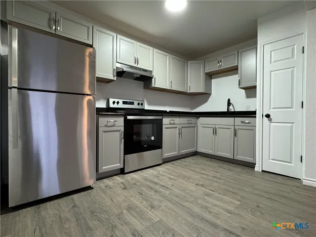 a kitchen with stainless steel appliances granite countertop a refrigerator sink and cabinets