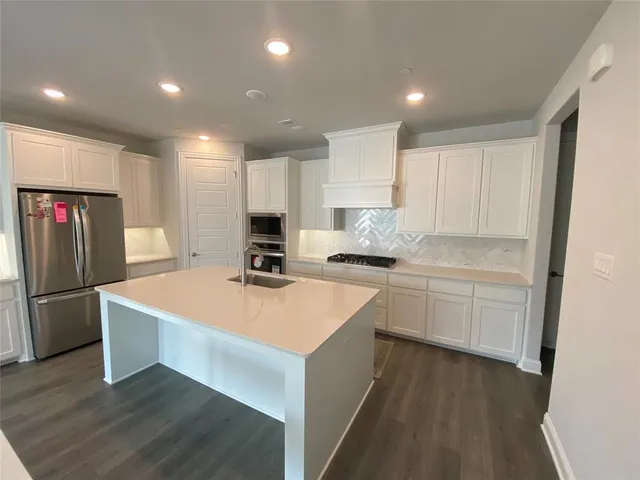 a kitchen with stainless steel appliances a refrigerator sink and cabinets