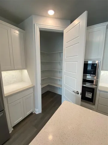 a kitchen with white cabinets and appliances