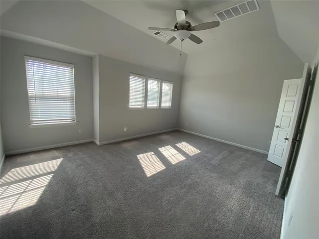 an empty room with windows and fan