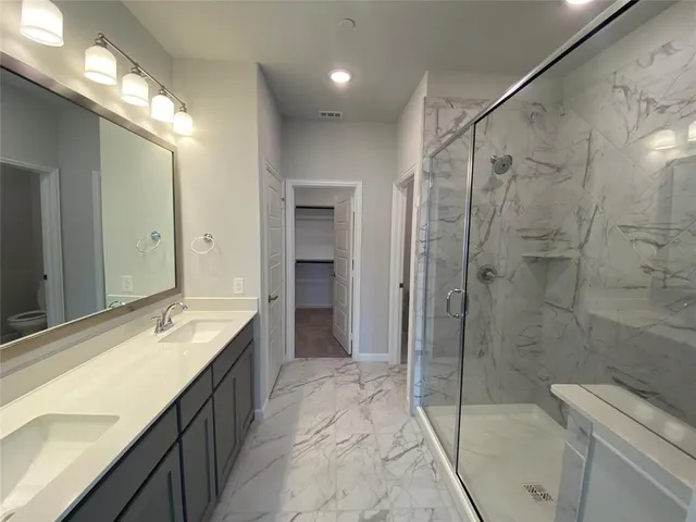 a spacious bathroom with a sink a toilet and shower