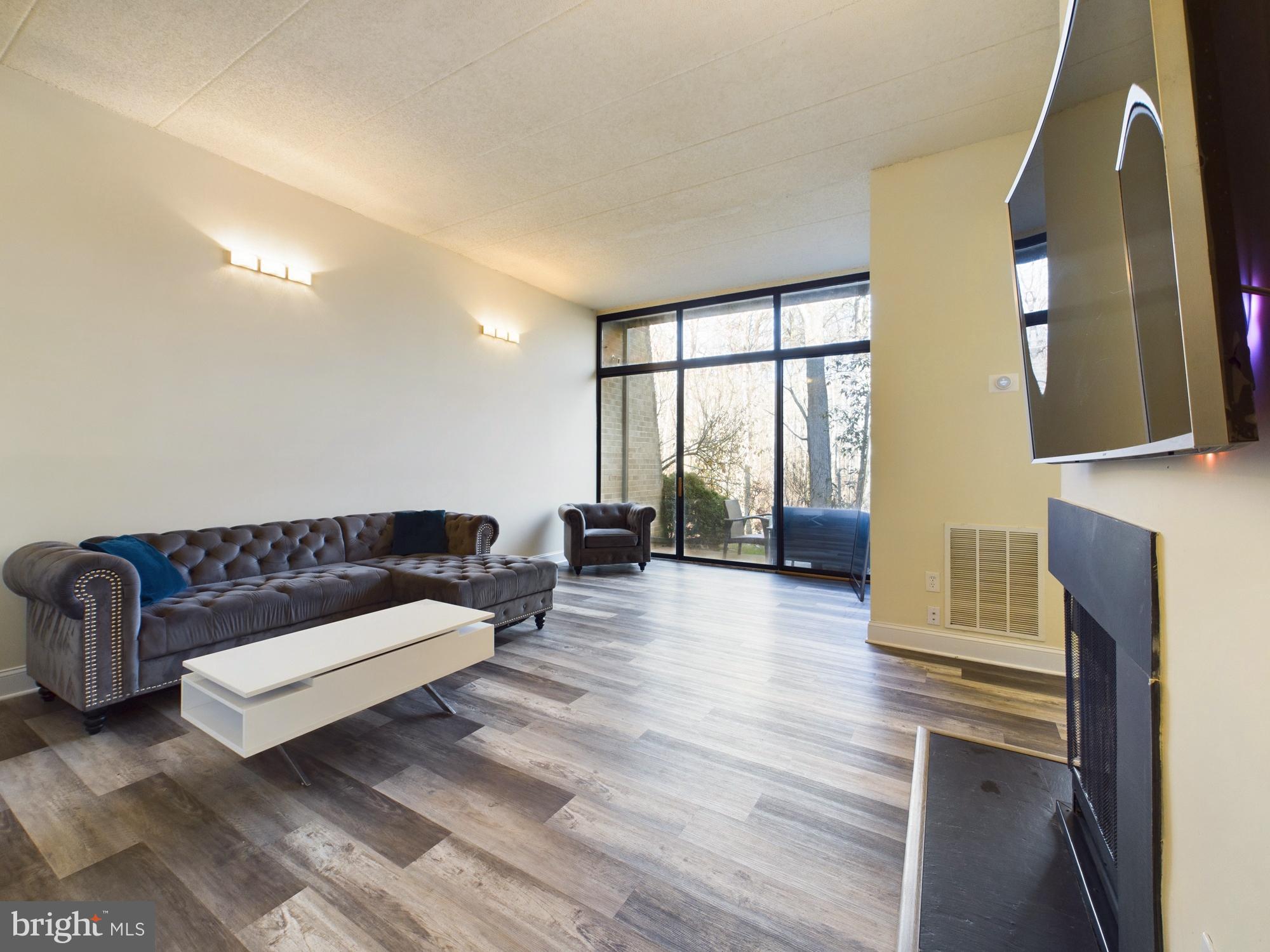 11566 Rolling Green Court, Unit 101 Reston, VA 20191 - Photo 1 of 38 a living room with furniture and a fireplace