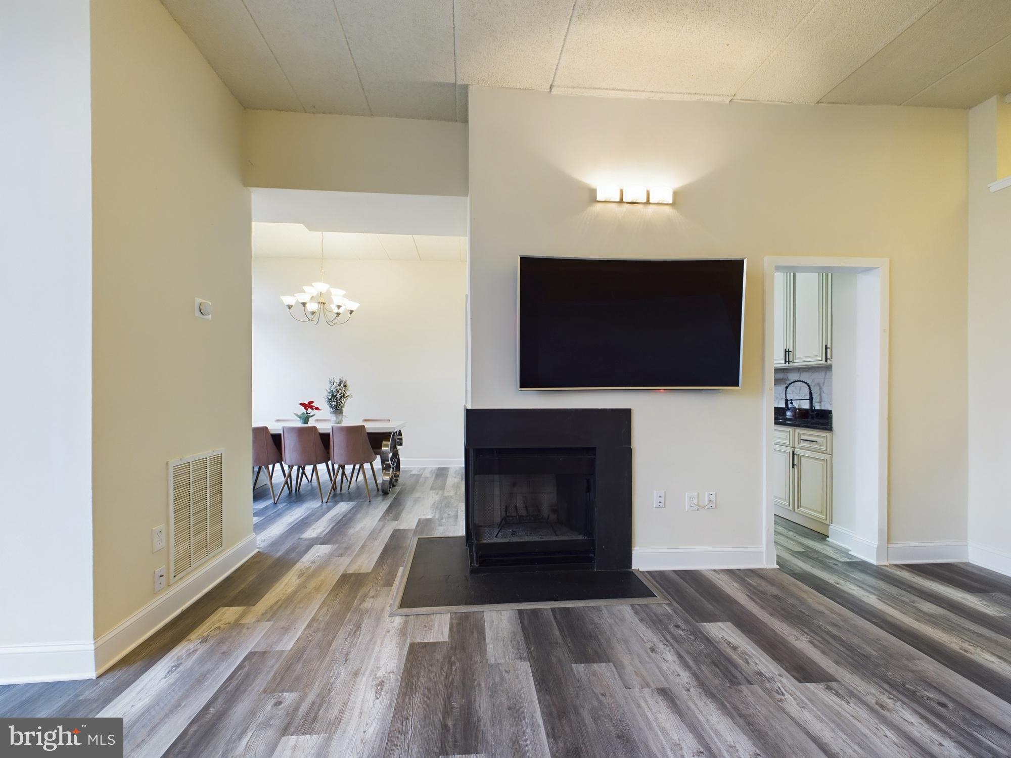 11566 Rolling Green Court, Unit 101 Reston, VA 20191 - Photo 12 of 38 a living room with furniture a flat screen tv and a fireplace