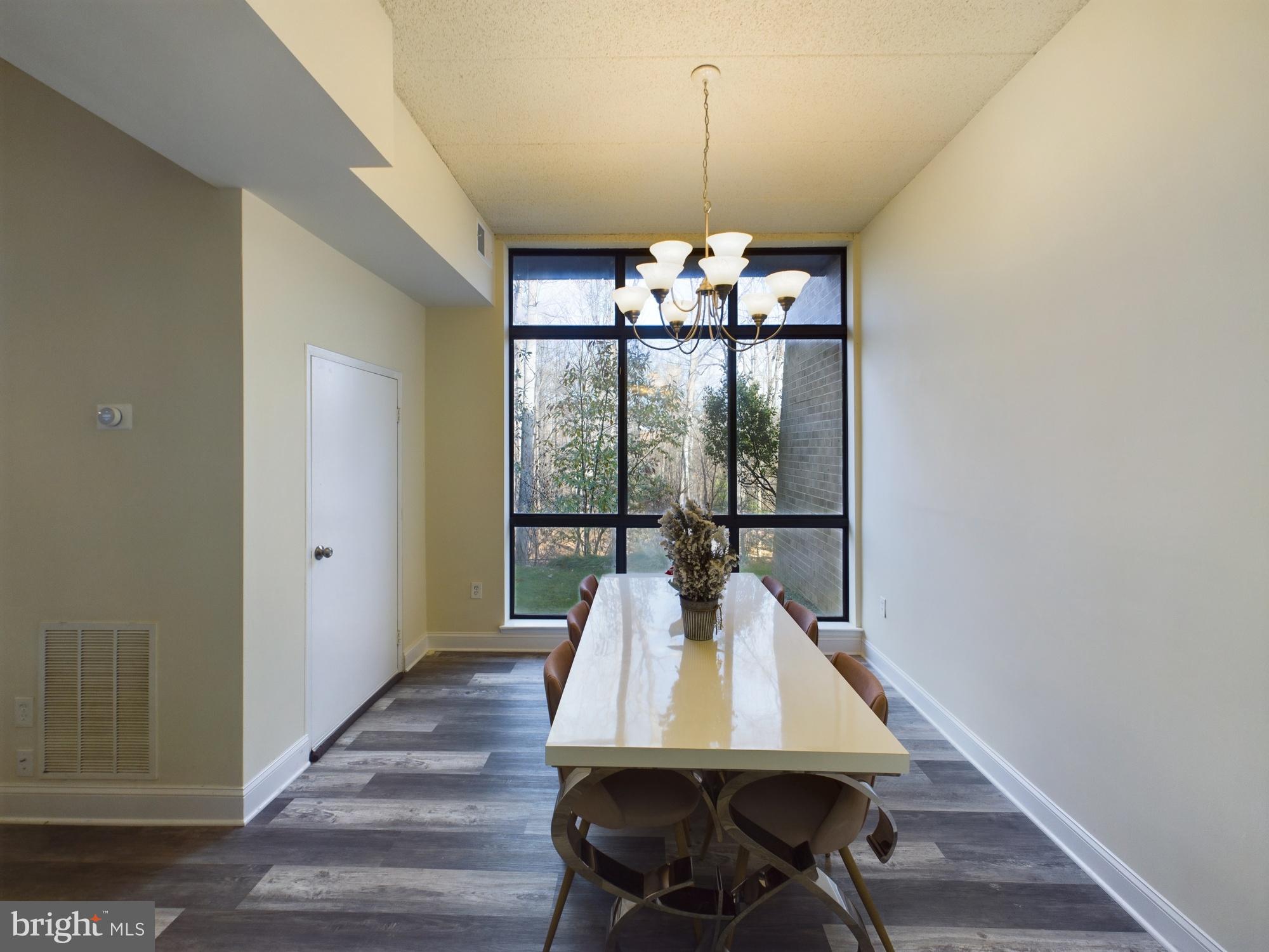 11566 Rolling Green Court, Unit 101 Reston, VA 20191 - Photo 15 of 38 a view of a dining room with furniture wooden floor and chandelier